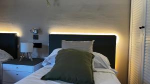 a bedroom with a bed with a green blanket and white pillows at Hotel Restaurant Europeu in Montmeló +8 photos
