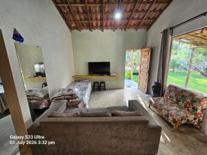 a living room with a couch and a tv at Sito Marinheiro in Porto Seguro