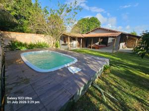 a backyard with a swimming pool on a wooden deck at Sito Marinheiro in Porto Seguro
