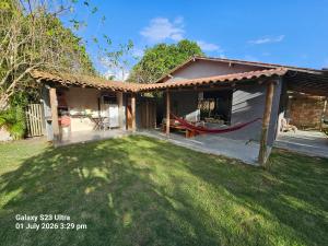 a house with a hammock in the yard at Sito Marinheiro in Porto Seguro