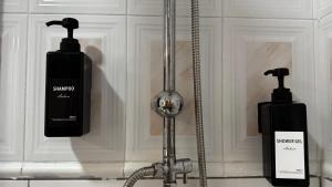 two soap dispensers on a wall next to a sink at Hotel Restaurant Europeu in Montmeló