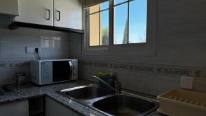 a kitchen with a sink and a microwave at Hotel Restaurant Europeu in Montmeló