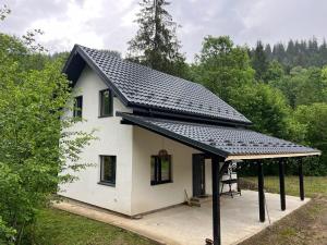 a small white house with a black roof at Forest Residens in Krasnik