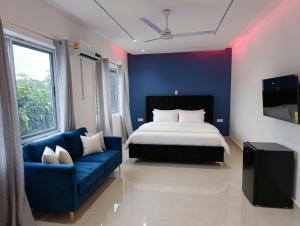 a bedroom with a bed and a blue couch at The Hills in Accra +20 photos