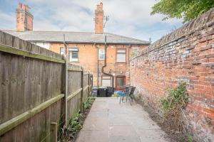 a brick wall with a bench in front of a building at 10 Northgate, Beccles in Beccles
