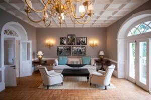 a living room with a chandelier and a couch and chairs at Belo Monte - Principe Collection in Santo António
