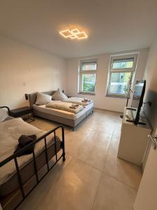 a bedroom with two beds and a flat screen tv at Am Zollverein House-In Apartments Essen - Free Parking - WiFi - Kitchen in Essen