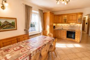 a kitchen with a table and chairs in a room at Rossetti 3 camere by AMA Val di Fassa in Pozza di Fassa