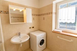 a bathroom with a washing machine and a sink at Rossetti 3 camere by AMA Val di Fassa in Pozza di Fassa