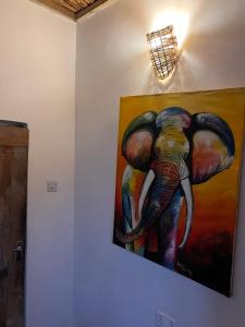 a painting of an elephant hanging on a wall at Mambo Leo Hostel in Paje