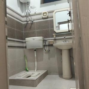 a bathroom with a toilet and a sink and a mirror at Royal hotel jaglot gilgit in Gilgit