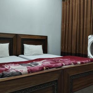a bedroom with two beds and a window with at Royal hotel jaglot gilgit in Gilgit