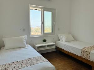two beds in a room with a window at Aelia in Vári