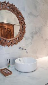 a bathroom with a white sink and a mirror at Heritage Stay in Bingin Beach