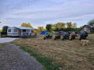 a group of motorcycles parked in a field with tents at Emplacement camping car terrain privé cher l'habitant à Plœuc-L'Hermitage in Pourhon