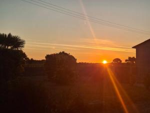 a sunset with the sun setting in the sky at Emplacement camping car terrain privé cher l'habitant à Plœuc-L'Hermitage in Pourhon +1 photo