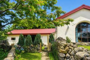a house with a stone fence and a yard at 공간서시 in Chin-dong