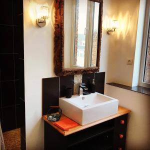 La salle de bains est pourvue d'un lavabo blanc et d'un miroir. dans l'établissement Le 34, à Armentières