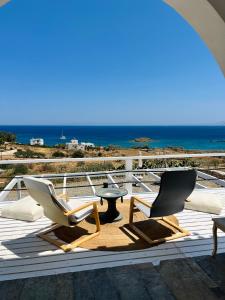 a patio with two chairs and a table and the ocean at Aelia in Vári