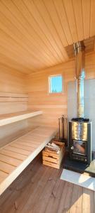 a wooden sauna with a wood stove in it at Lakeview Houses Sweden in Falun