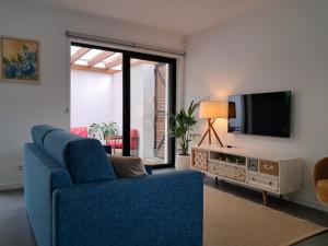 a living room with a blue couch and a tv at Furnas Springs in Furnas