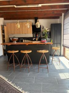 a kitchen with a counter and stools in a room at Gîte d'exception pour 2 personnes in Mietesheim