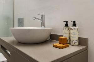 ein Badezimmer mit einem Waschbecken und zwei Flaschen auf einer Ablage in der Unterkunft SAL Collection Hotel in Aveiro + 47 Fotos