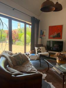a living room with a couch and a large window at Gîte d'exception pour 2 personnes in Mietesheim