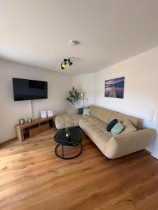 a living room with a couch and a flat screen tv at Ferienwohnung "Große Auszeit" in Schongau