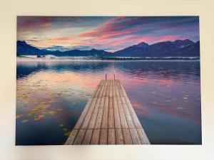 a wooden dock on a lake with a sunset at Ferienwohnung "Große Auszeit" in Schongau