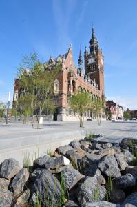 a building with a clock tower with rocks in front of it at Le 34 in Armentières