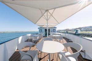 a balcony with tables and chairs on a cruise ship at Costa do Sal Hotel Boat Lounge in Aveiro