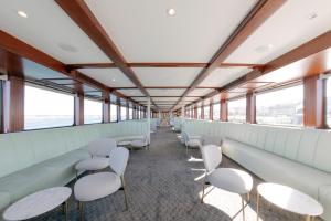 an empty waiting room with white chairs and windows at Costa do Sal Hotel Boat Lounge in Aveiro