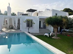 a villa with a swimming pool in front of a house at CASA PIZZI in Agua Amarga