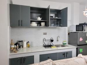 a kitchen with black cabinets and a sink and a refrigerator at KilimaVista Homes 1 bedroom apartment in Kimana