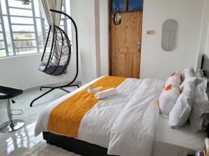 a bedroom with a large white bed with towels on it at KilimaVista Homes 1 bedroom apartment in Kimana