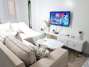 a living room with a couch and a tv on a wall at KilimaVista Homes 1 bedroom apartment in Kimana
