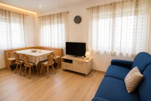 a living room with a table and a tv at Appartamenti Col Rodella by AMA Val di Fassa in Campitello di Fassa