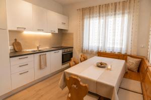 a kitchen with a table and a kitchen with white cabinets at Appartamenti Col Rodella by AMA Val di Fassa in Campitello di Fassa