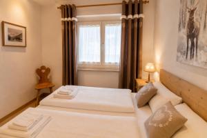a bedroom with two beds and a window at Appartamenti Col Rodella by AMA Val di Fassa in Campitello di Fassa