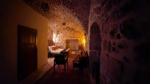 a room with a bed and chairs in a stone wall at Terrace Merdin Konagı in Mardin +16 photos