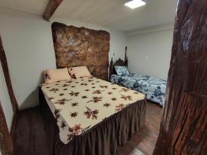 a bedroom with a bed with a comforter on it at Alpes Goianos - Suítes in Cavalcante +23 photos