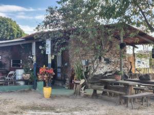 a building with a picnic table and a picnic bench at Alpes Goianos - Suítes in Cavalcante