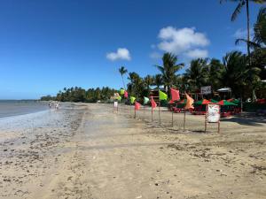 a beach with chairs and umbrellas and the ocean at Pousada Caranguejo in Cairu