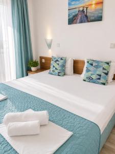 a bedroom with a large bed with towels on it at Tabanov Beach Hotel in Sozopol