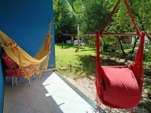 two hammocks hanging from the side of a house at Pousada Caranguejo in Cairu