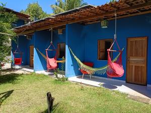 a blue house with two hammocks hanging from it at Pousada Caranguejo in Cairu