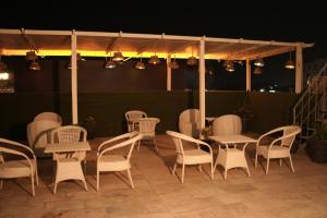 a group of chairs and tables on a patio at night at Hotel Clover in Zirakpur