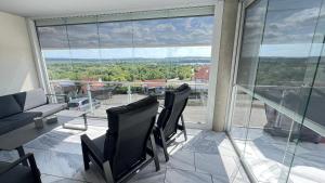 a living room with chairs and a table and a large window at FeWo-Brombachseeblick in Absberg