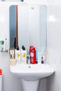 a bathroom sink with toiletries on it in front of a mirror at Lumi living hostel in Ho Chi Minh City